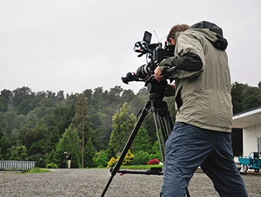 Camera operator filming outdoors
