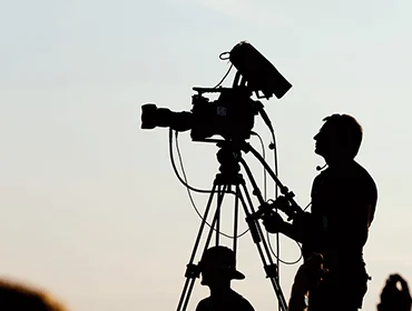 Camera operator silhouetted at dusk
